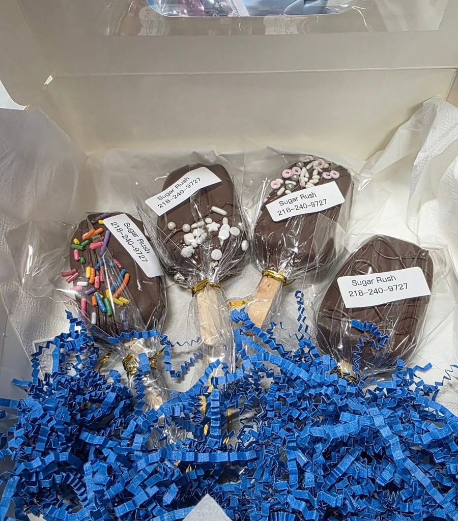 Boxed set of four chocolate cakesicles on blue crinkle paper